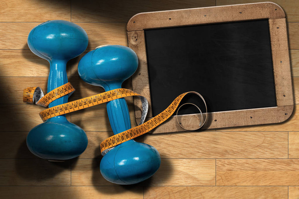 Két régi kék súlyzó edzés vagy fitness (szabad súlyok) narancssárga mérőszalag és üres tábla egy fából készült tornaterem padlón parketta. - Fotó, kép