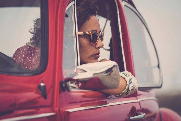 赤の伝説のレトロなヴィンテージ車の中ポーズ中年女性ドライバー - 写真・画像