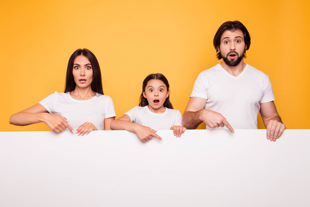 Portrait of nice attractive shocked confused people dad mom holding in hands showing new information blank empty copy space place isolated over shine vivid pastel yellow background - Fotoğraf, Görsel