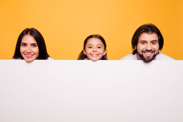 Portrait of nice attractive lovely cheerful cheery people dad mom face above new information desk blank empty copy space place isolated over shine vivid pastel yellow background - Fotoğraf, Görsel