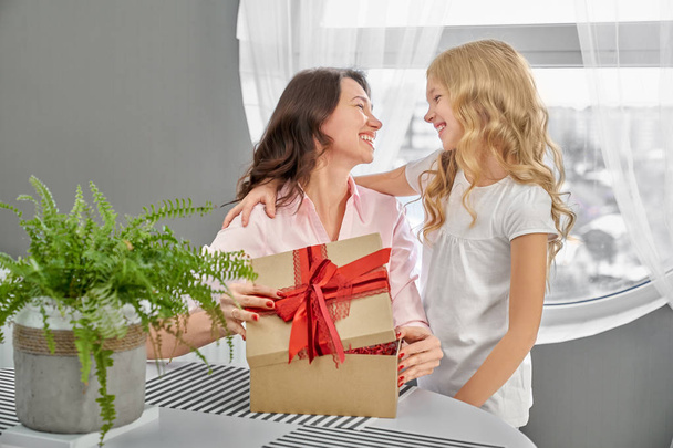 Daughter giving to happy mother present. - Foto, afbeelding
