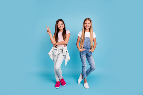 Full length body size view portrait of two people nice lovely charming attractive cheerful straight-haired pre-teen girls siblings showing v-sign isolated on blue turquoise background - Φωτογραφία, εικόνα