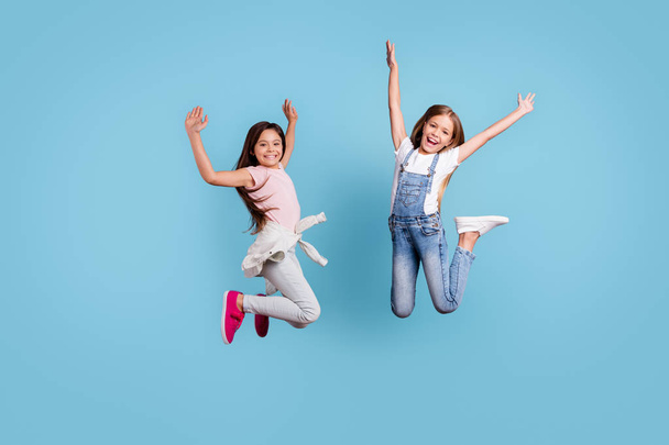 Full length body size view of two people nice lovely attractive charming cheerful crazy careless straight-haired pre-teen girls rejoicing overjoy cool day isolated over blue pastel background - Fotó, kép
