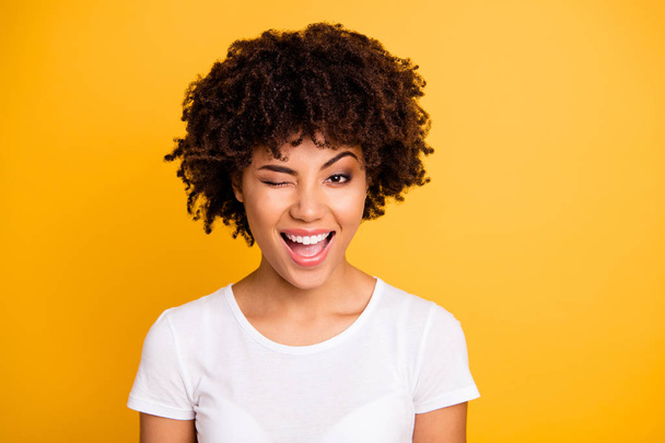 Close up photo pretty amazing she her dark skin lady cool look glad winking one eye mouth open laugh laughter wearing casual white t-shirt isolated yellow bright vibrant vivid background - Foto, Imagem