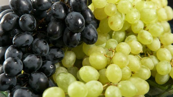 Зелено-блакитна група винограду, що лежить на тарілці
. - Фото, зображення