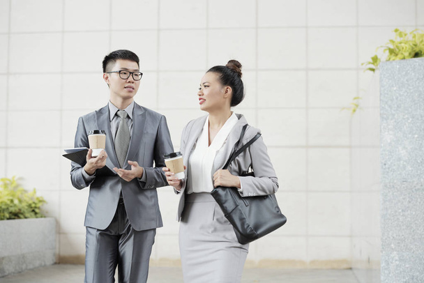 Asian young business people with take away coffee standing outdoors - Photo, Image