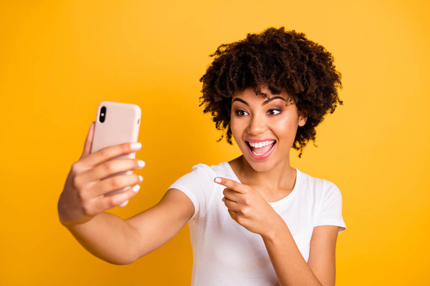 Close-up portrait of her she nice cute attractive lovely cheerful wavy-haired lady holding in hands cell making selfie video call pointing at screen isolated on bright vivid shine yellow background - Φωτογραφία, εικόνα