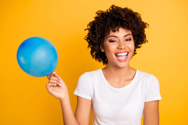 Close up photo beautiful amazing she her dark skin lady hold air balloon hands arms excited funky voice breath in helium wear casual white t-shirt isolated yellow bright vibrant vivid background - Fotó, kép