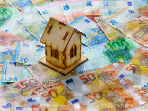 a bunch of european euro currency and a wooden house - Fotó, kép