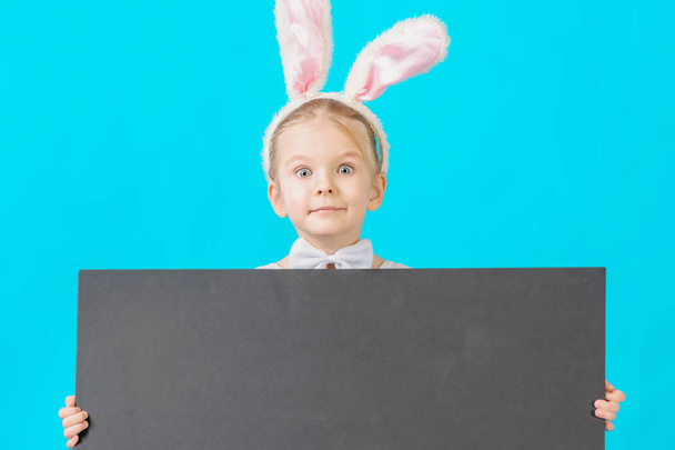 Маленькая девочка в белом костюме кролика держит пустой лист с местом для текста
 - Фото, изображение