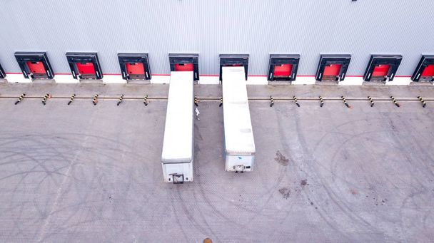Tiro aéreo del muelle de carga del almacén industrial donde muchos camiones con semirremolques cargan mercancías. Antena
 - Foto, imagen