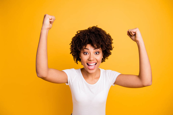 Close up photo beautiful amazing she her dark skin lady not believe yelling glad hands arms fists raised great big win competition wear casual white t-shirt isolated yellow bright vibrant background - Foto, Bild