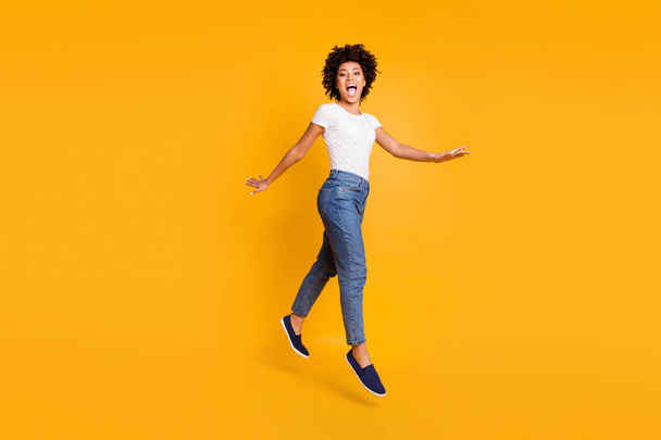 Full length body size side profile photo jumping high beautiful she her lady yelling rushing shopping low prices amazed wearing casual jeans denim white t-shirt clothes isolated yellow background - Foto, Imagen