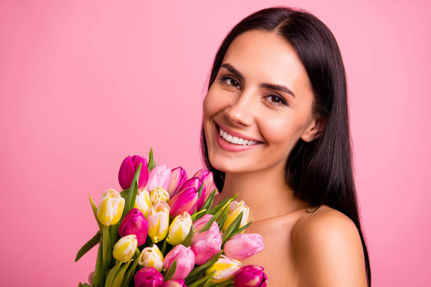Close-up portrait of her she nice cute attractive lovely winsome charming feminine fascinating gentle cheerful brunette lady smelling colorful fresh natural flowers isolated on pink pastel background - Valokuva, kuva