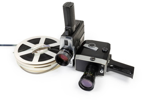 Két különböző vintage amatőr film film fényképezőgép és tekercs színes mozgókép filmek Super 8 mm-es formátumban közelről a fehér háttér - Fotó, kép