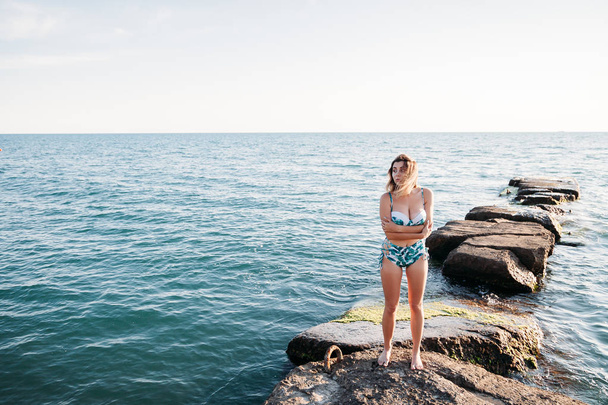 Genç kadın modeli bikini daimi mavi gökyüzü gülümseyen in açık atış. Bir yaz gününde dışarıda eğleniyor kadın. - Fotoğraf, Görsel