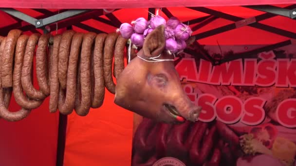 Cabeza de cerdo ahumado y salchichas en feria agrícola callejera
 - Imágenes, Vídeo