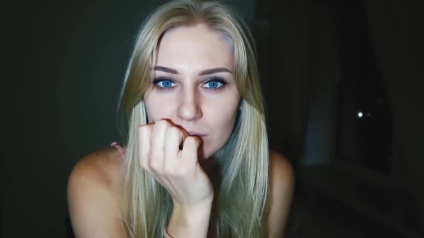 Mladá krásná blonďatá žena s jasně modrými velkými oči hledí do kamery a bojí se, zavřela oči v ruce, aby se bála - Záběry, video
