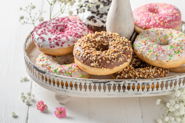 Delicious and sweet donuts on white wooden table - Foto, Imagen