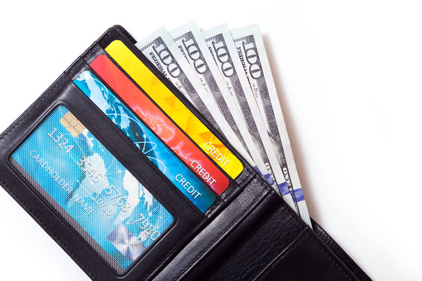 Gros plan d'un portefeuille en cuir noir avec des cartes de crédit colorées et nous dollars dedans, isolé sur fond blanc
 - Photo, image