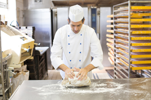 Baker kneading dough in bakery - Fotografie, Obrázek