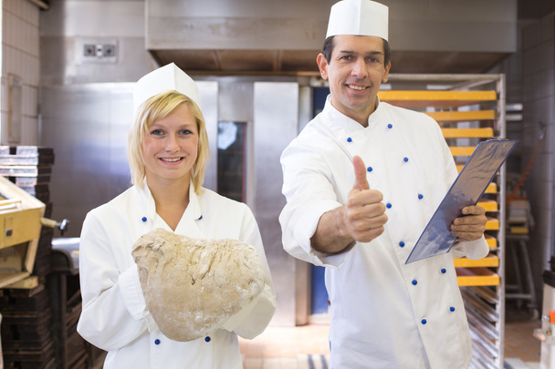 Baker with bread dough in bakery - Foto, immagini