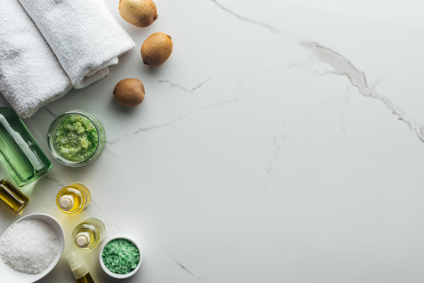 vista superior de ingredientes naturales para cosméticos hechos a mano, toallas y botellas en superficie blanca
 - Foto, Imagen