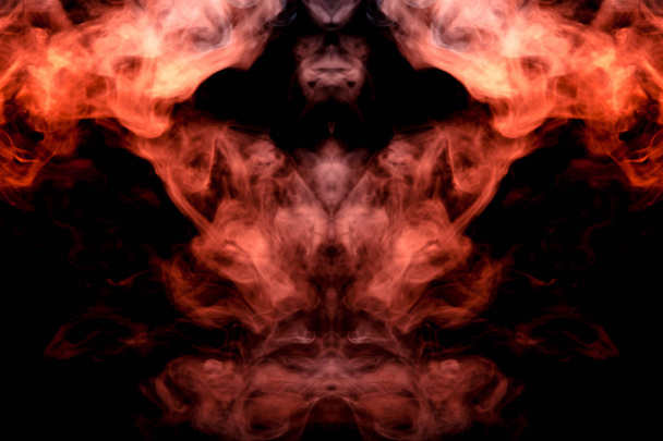 Um padrão místico de fumaça colorida de vermelho e branco na forma de um rosto de fantasma com presas criando uma sensação de medo em um fundo isolado preto de um filme de terror, mocap e impressão para t-shirt
 - Foto, Imagem