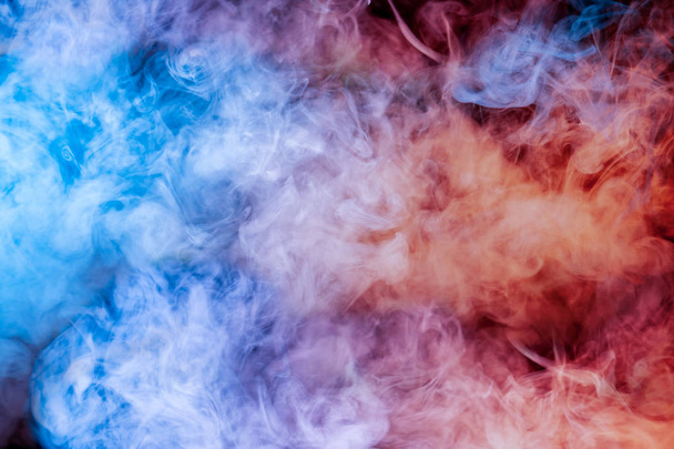 Translucent, thick smoke, illuminated by light against a dark background, divided into three colors: blue, green, pink and purple, burns out, evaporating from a steam of vape for print on t-shirt - 写真・画像