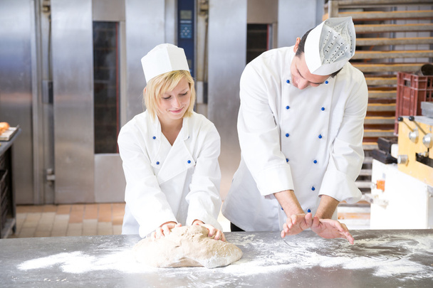 Baker instruction apprentice in kneading bread dough - Fotoğraf, Görsel