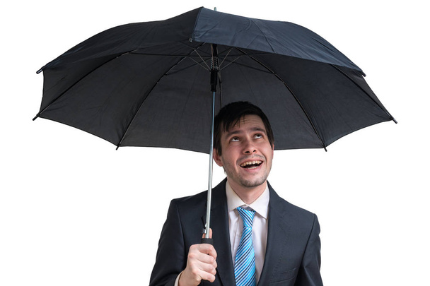 Νεαρός ευτυχής επιχειρηματίας με μαύρη ομπρέλα. Απομονωμένα σε λευκό φόντο. - Φωτογραφία, εικόνα