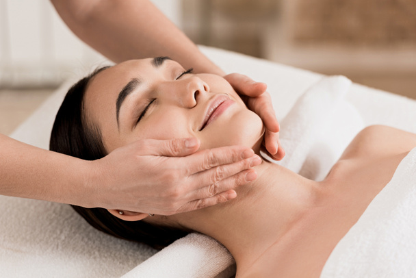  donna ottenere massaggio viso con gli occhi chiusi al centro benessere
  - Foto, immagini