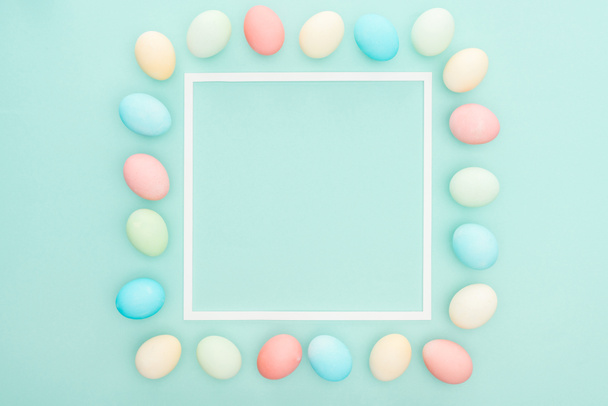 top view of pastel easter eggs near empty frame isolated on blue - Foto, immagini