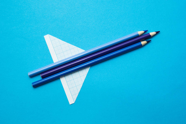 Blue rocket from school pencils and paper on a blue background. - Foto, Bild