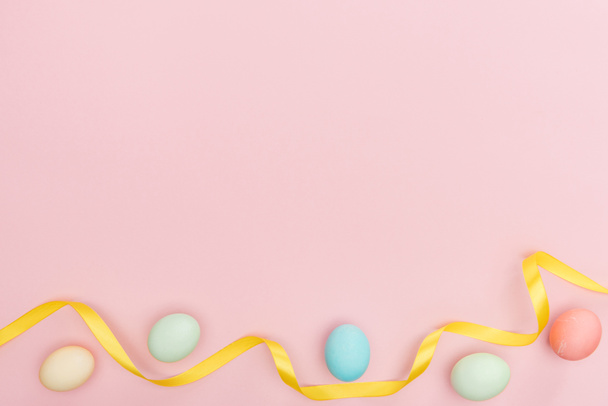 top view of ribbon and pastel easter eggs isolated on pink - Valokuva, kuva