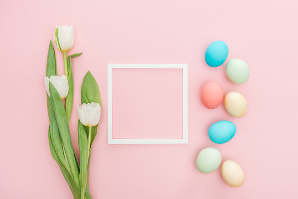 top view of tulip flowers and easter eggs with frame isolated on pink - Fotografie, Obrázek