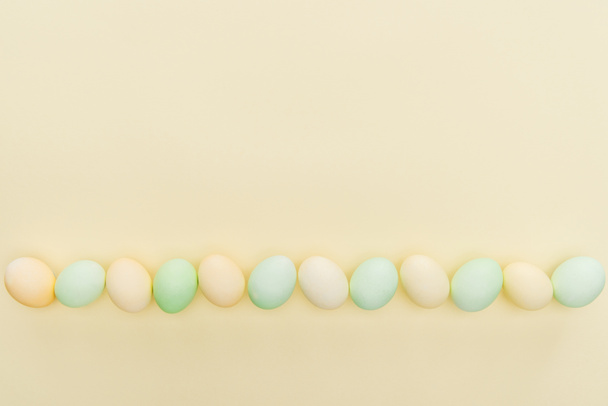 traditional pastel easter eggs in row isolated on yellow - Photo, Image