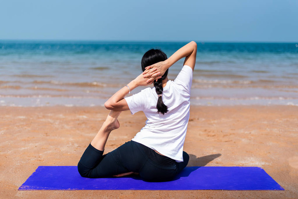 Holka dělá jógu na pláži zadní pohled - Fotografie, Obrázek