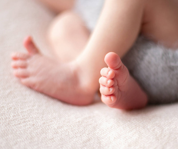 Zachte baby voeten. Zachte onscherpe achtergrond van de voeten en de hielen van een pasgeboren baby - Foto, afbeelding