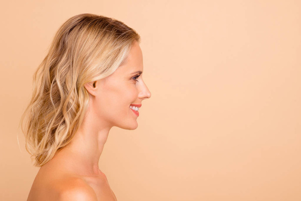 Facial detox ad concept. Profile side view portrait of her she attractive cheerful wavy-haired nude lady with fresh clear clean flawless smooth skin copy empty blank space isolated on beige background - 写真・画像
