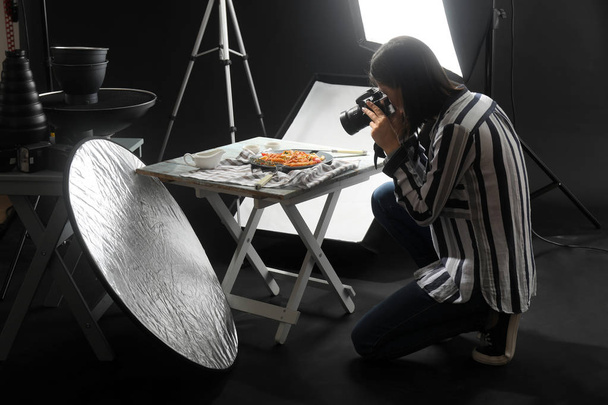 Молодая женщина фотографирует вкусную пасту в профессиональной фотостудии
 - Фото, изображение
