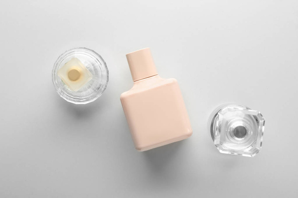 Bottles of perfume on light background - Foto, Imagen