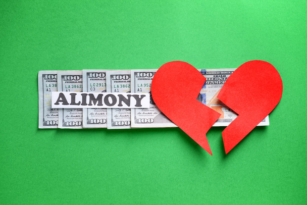 Palabra ALIMONIA con el corazón roto y el dinero en el fondo de color
 - Foto, Imagen