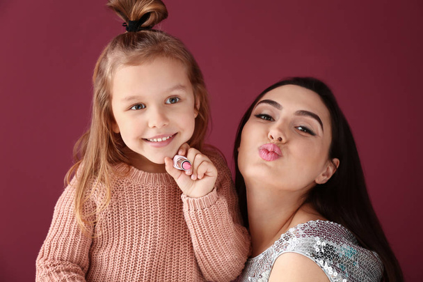 Πορτρέτο του χαριτωμένο μικρό κορίτσι με τη μητέρα σε χρώμα φόντου - Φωτογραφία, εικόνα