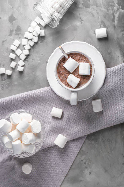 Xícara de bebida de cacau quente com marshmallows na mesa cinza
 - Foto, Imagem