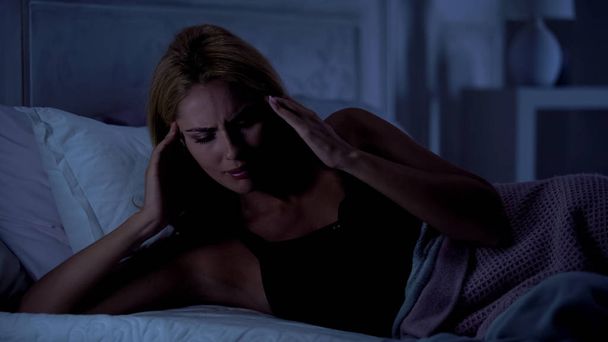 Woman suffering migraine, rubbing her temples, having bad sleep, stressful job - Zdjęcie, obraz