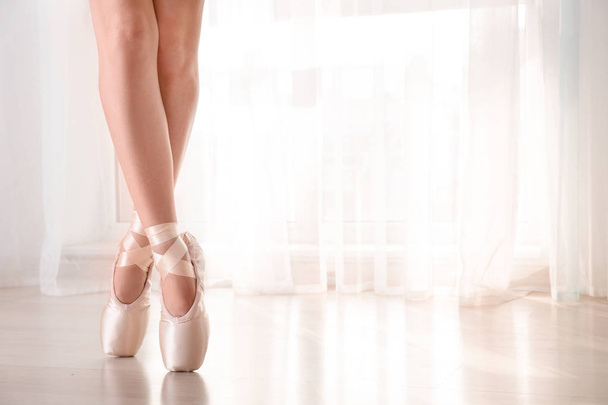 Jovem bailarina de balé usando sapatos pontiagudos dentro de casa
 - Foto, Imagem