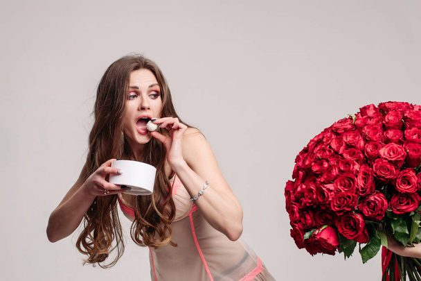 Vicces nő eszik édességet, és fut el bouquet - Fotó, kép