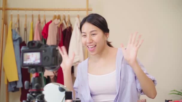 Zwolnionym tempie - uroda blogger obecnie kosmetyki siedzi z przodu kamery do nagrywania wideo. Szczęśliwy młody piękny Asian kobieta stosowanie kosmetyków przegląd tworzą samouczek transmisji wideo na żywo. - Materiał filmowy, wideo