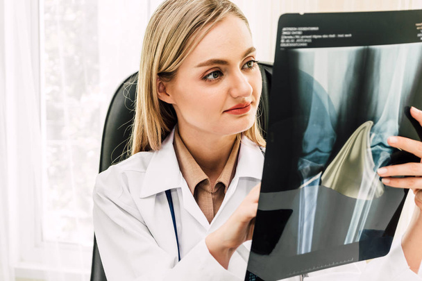 Médico femenino que mira la foto de rayos X en el hospital.healthcare y medicina
 - Foto, imagen